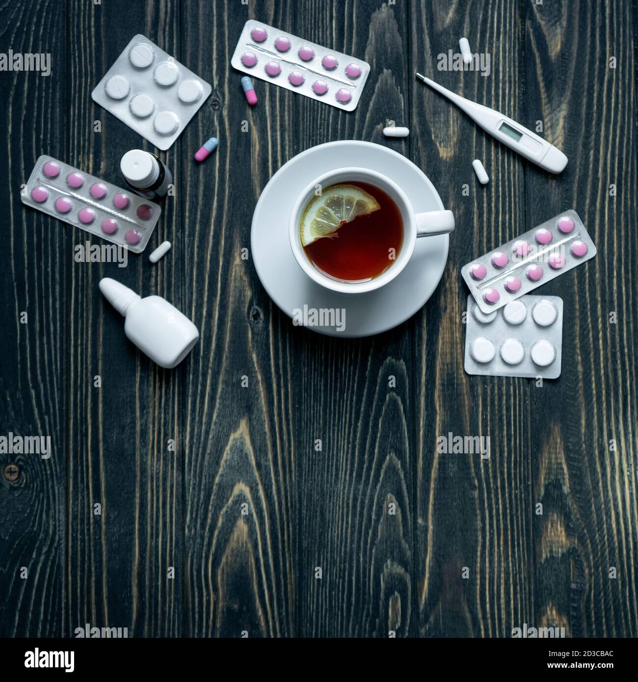 vue de dessus d'une tasse de thé, de pilules et de thermomètre sur fond de bois. Banque D'Images