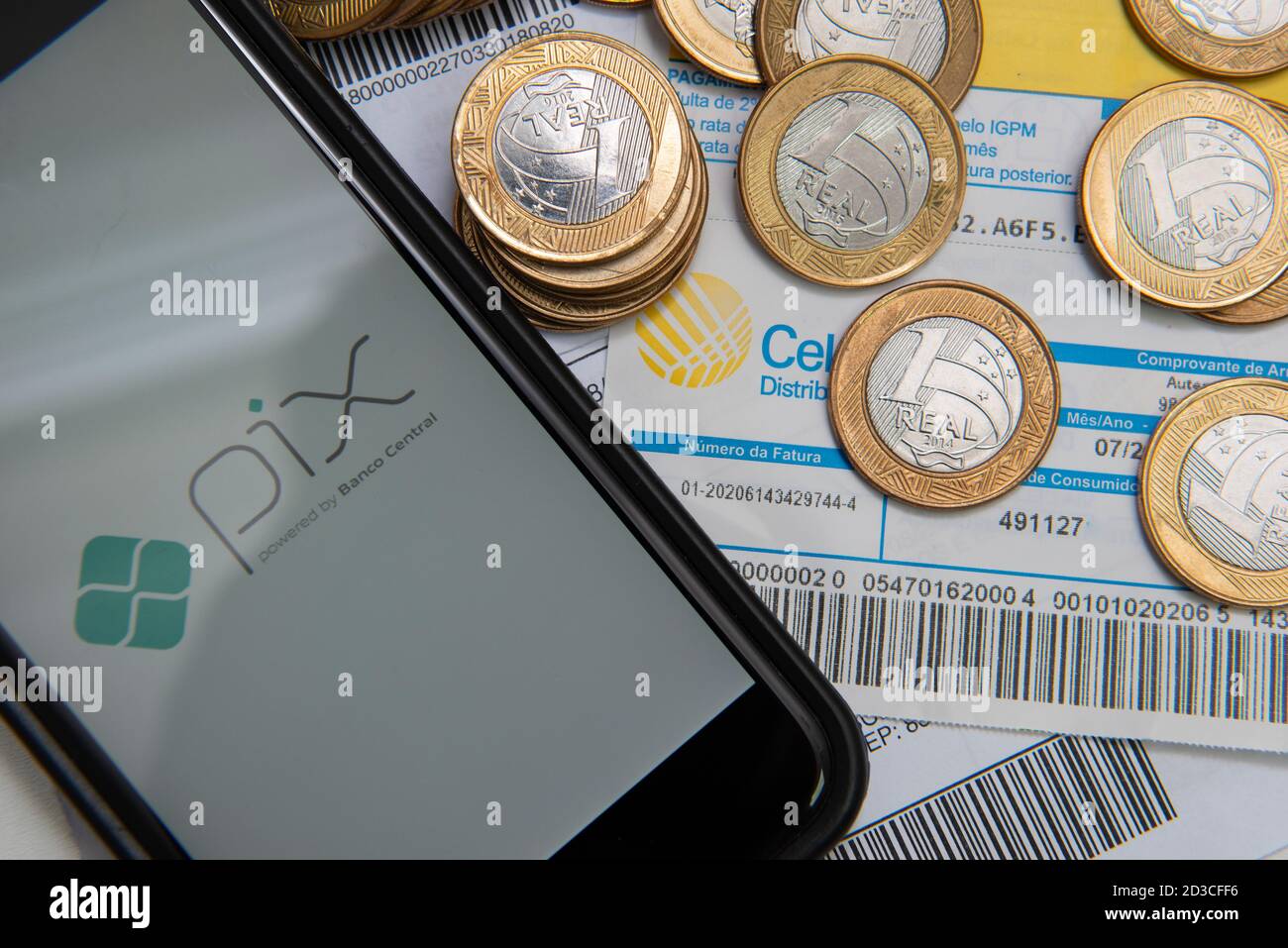 Florianopolis, Brésil. 07/10/2020: Gros plan du logo PIX sur l'écran du smartphone et pièces de monnaie sur les factures et les factures à payer avec code-barres. PIX est la nouvelle Centra Banque D'Images