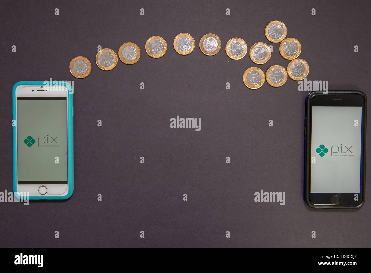 Florianopolis, Brésil. 07/10/2020: Flèche faite par 1 pièces de monnaie réelles montrant le transfert d'argent d'un smartphone à un autre. Concept de paiement instantané Banque D'Images