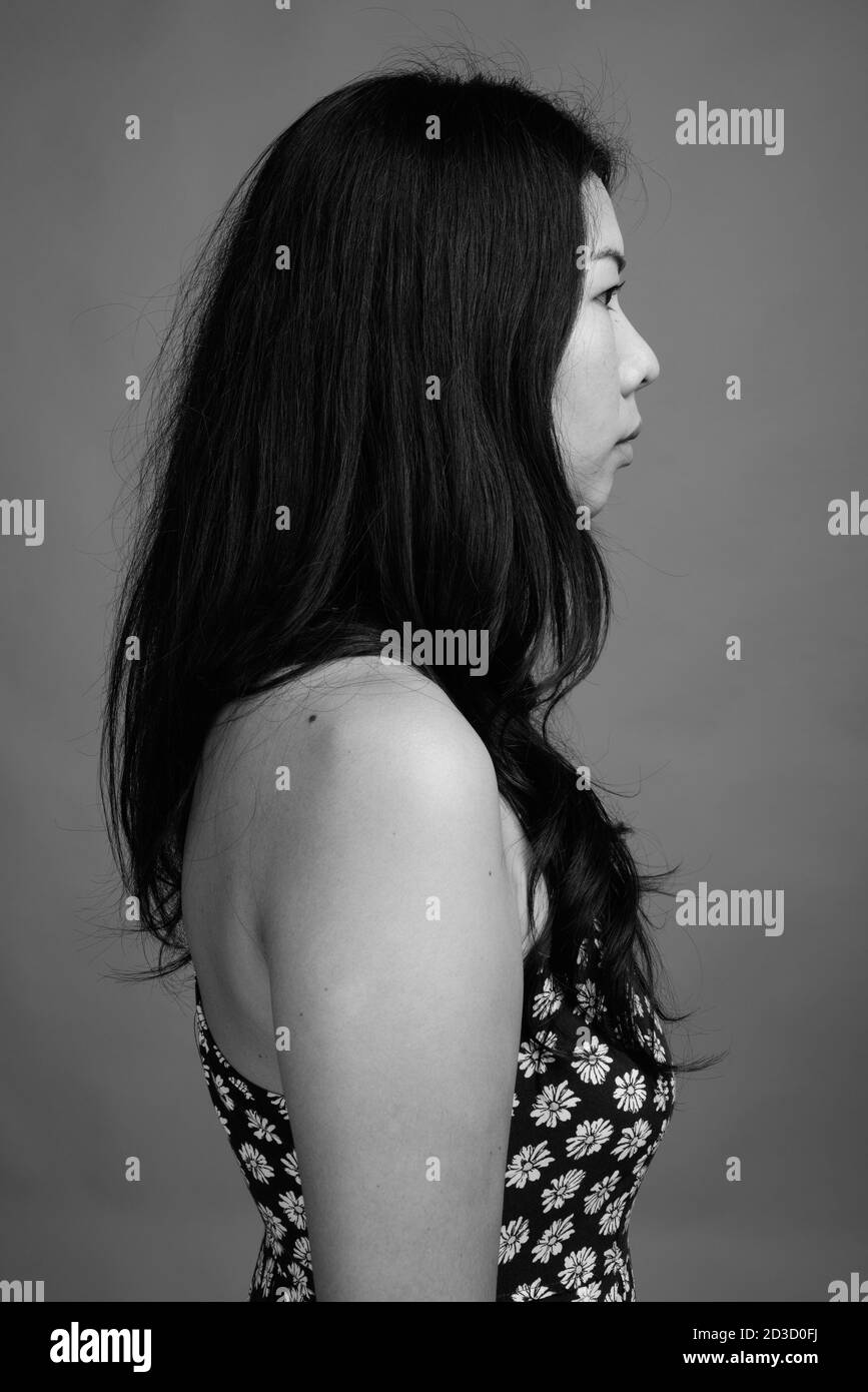 Femme asiatique portant une robe sur fond gris Banque D'Images