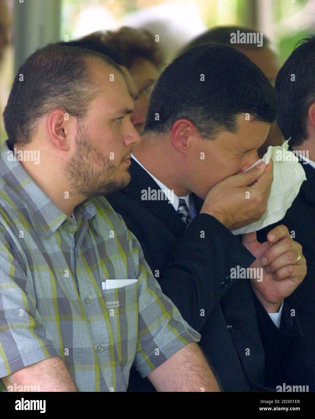 Russell Yates (R) wipes his face while attending graveside services for his  five children, June 27, 2001 in Houston. The five children, whose mother is  accused of drowning them, were buried on