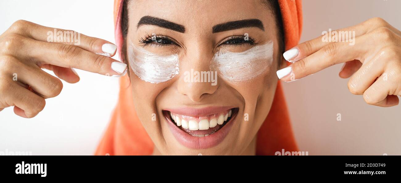 Happy girl appliquant la crème faciale quotidienne - Jeune femme ayant soin de peau jour spa - beauté saine traitement propre et produits de cosmologie concept Banque D'Images