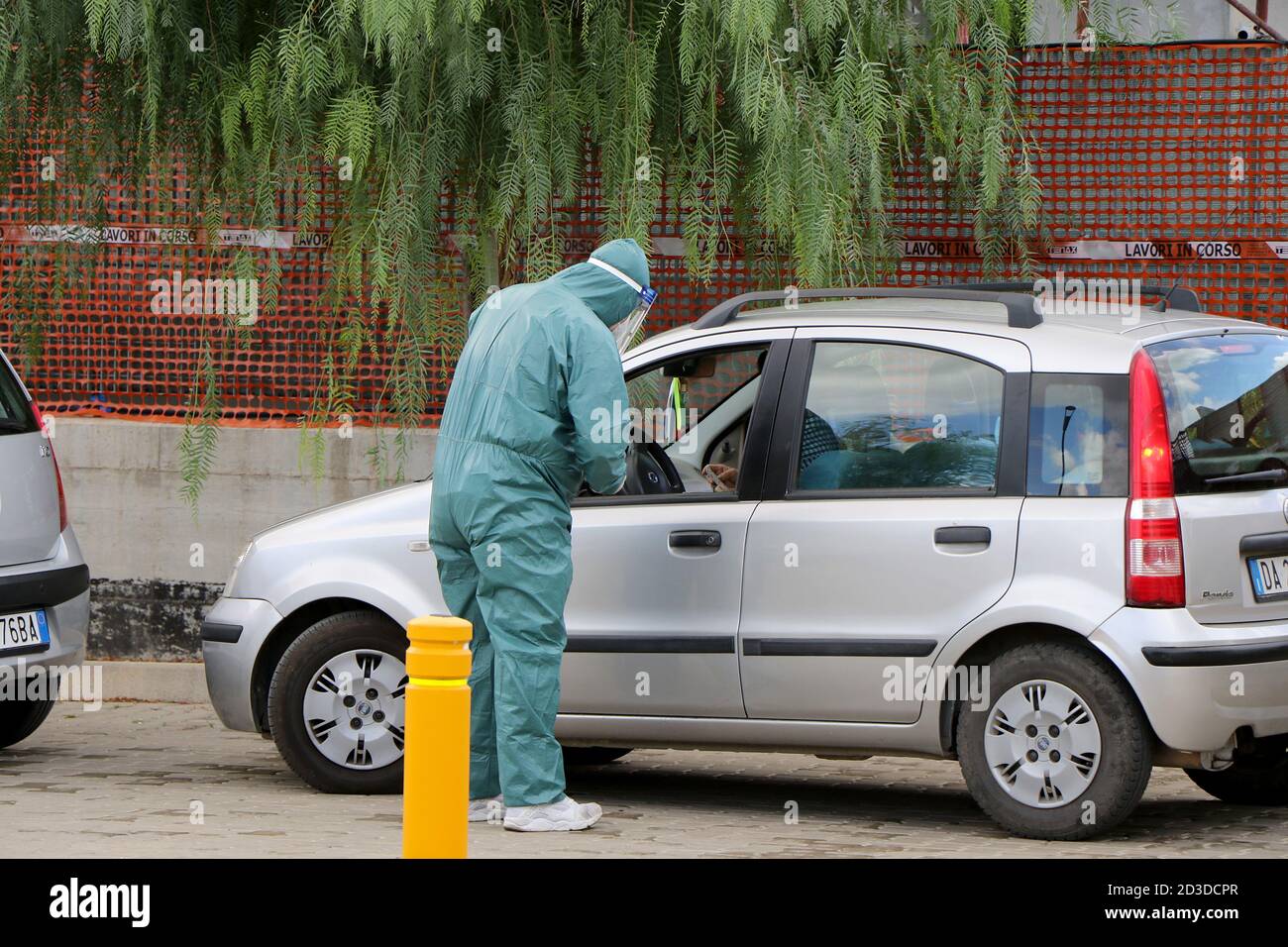 Les infirmières italiennes avec des combinaisons de protection, des masques et des gants font les écouvillons nasaux aux citoyens dans ses voitures en raison d'un cas possible de coronavirus Banque D'Images