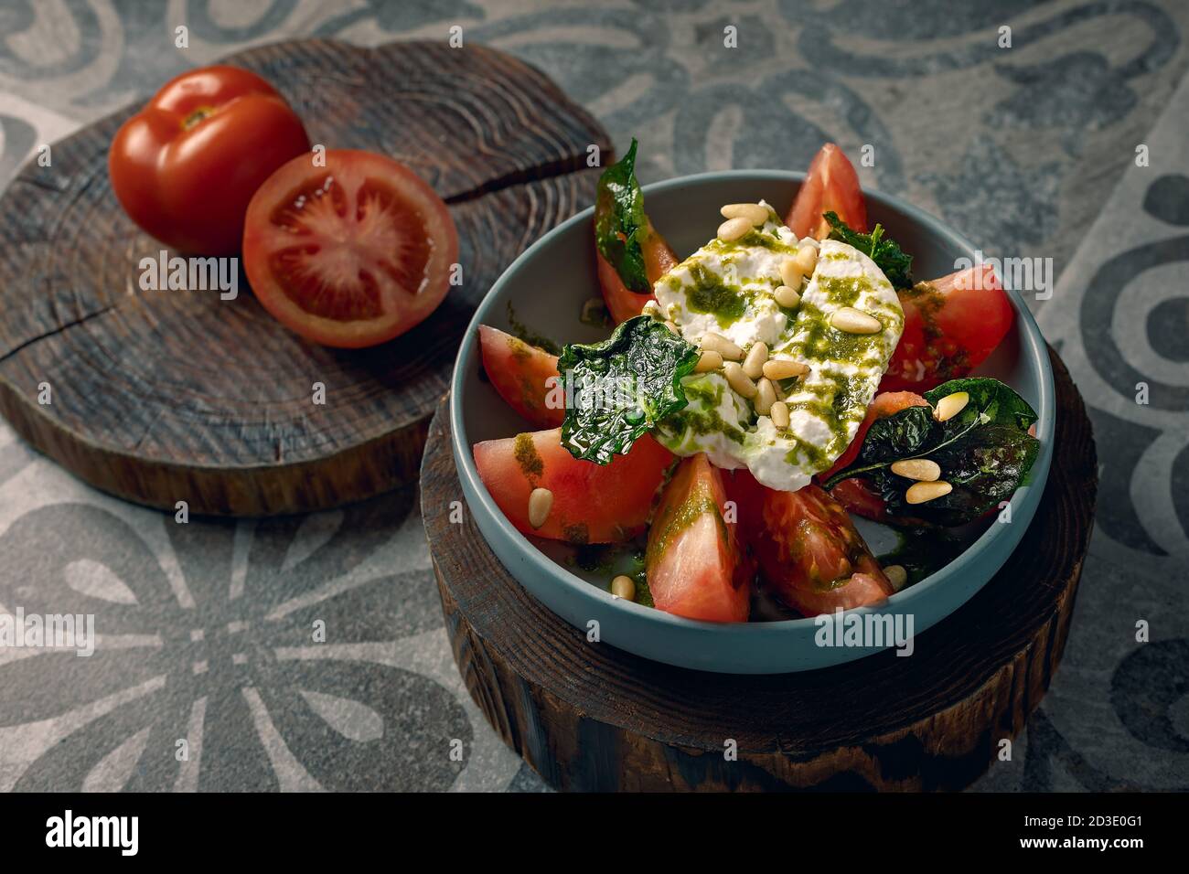 Salade de tomates fraîches et de mozzarella servie avec du pesto et des pignons de pin. Banque D'Images