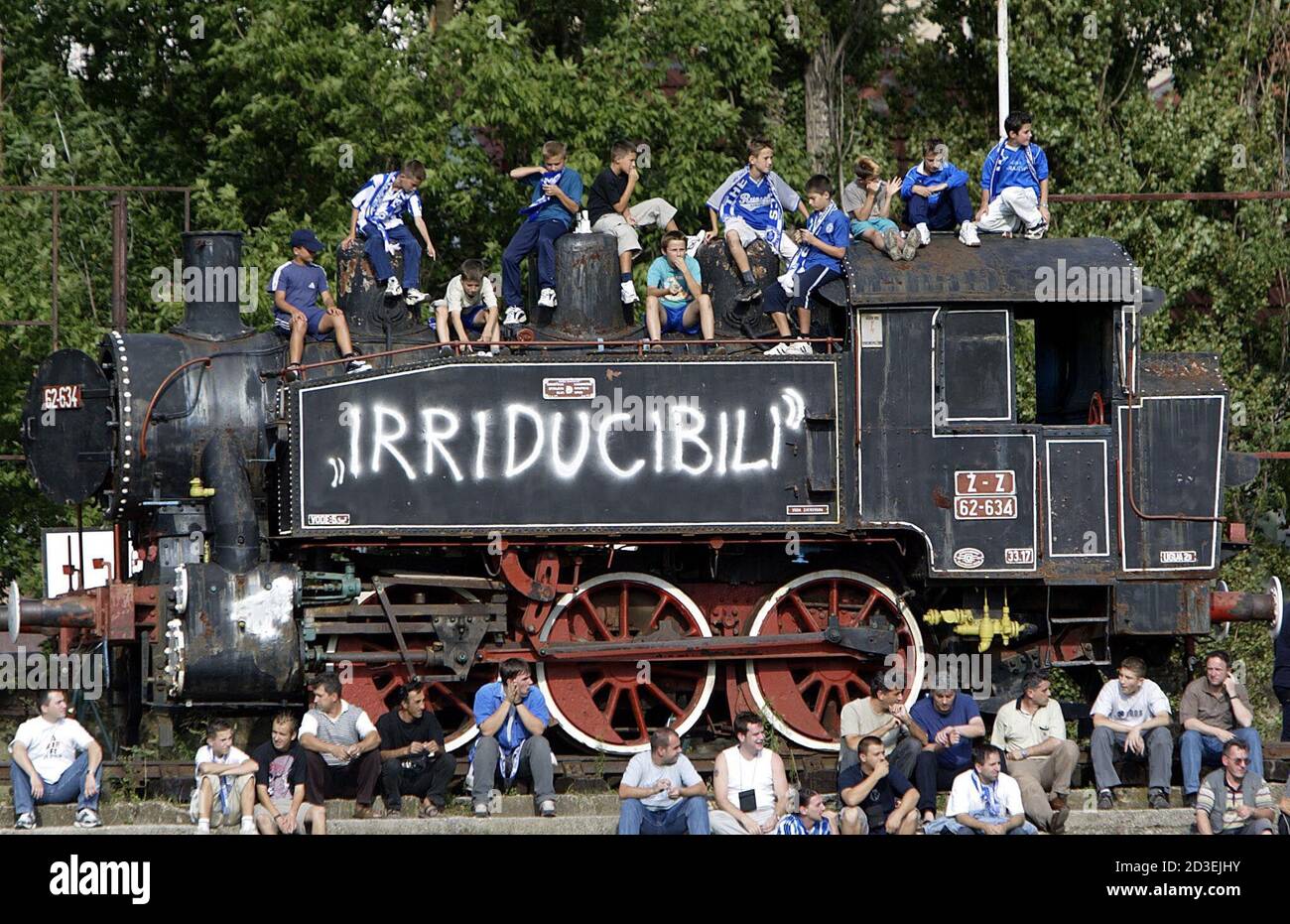 Supporters of the Bosnian champion FK Zeljeznicar (railwayman) sit atop of  an old locomotive as they watch a national league match at the Grbavica  Stadium in Sarajevo August 10, 2002, [the last