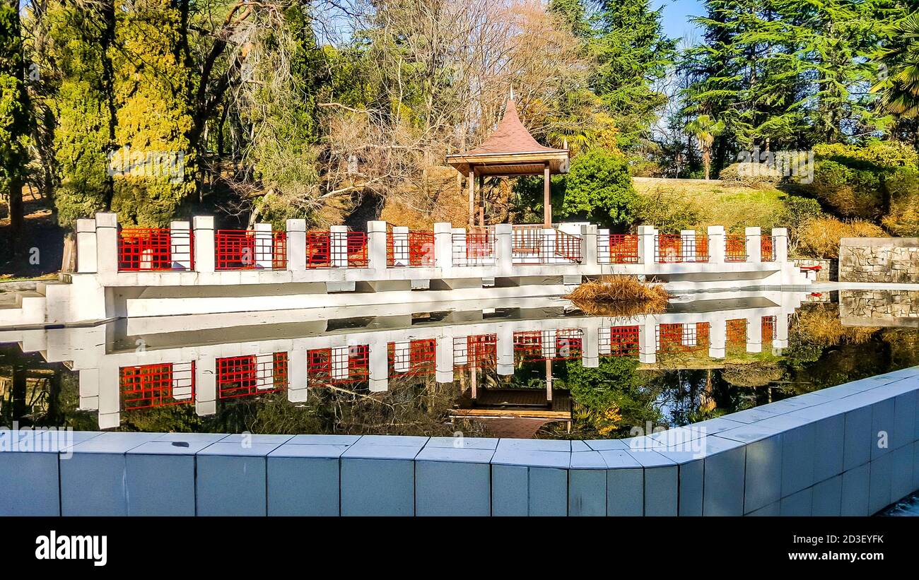 Belvédère en bois et étang encadré de pierre blanche dans l'arboretum de Sotchi. Russie Banque D'Images