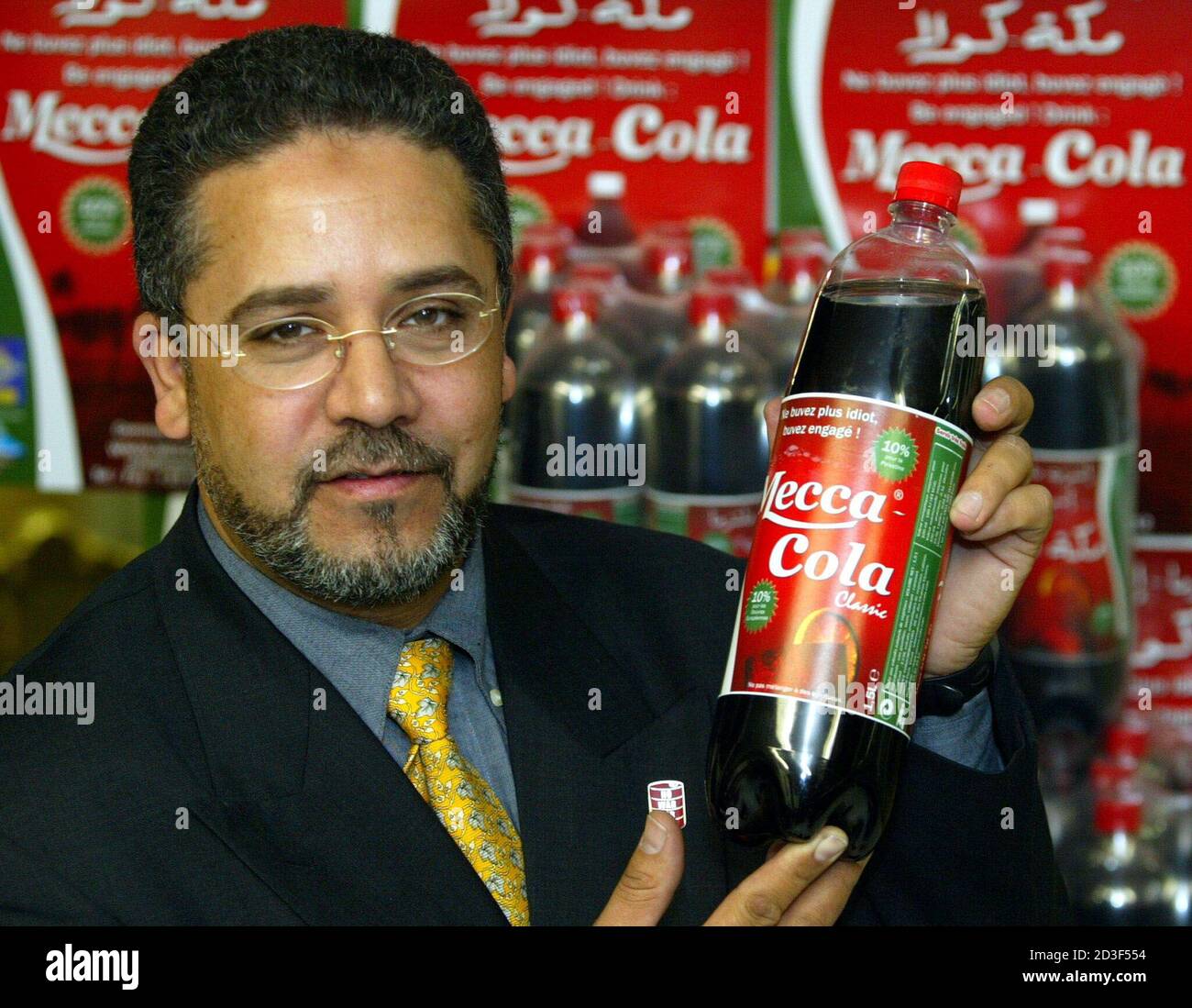 Businessman Tawfiq Mathlouthi holds a 1.5 litre bottle of his new soft  drink named Mecca Cola in offices at Saint Denis, near Paris on November 8,  2002. Mathlouthi, a director of Radio