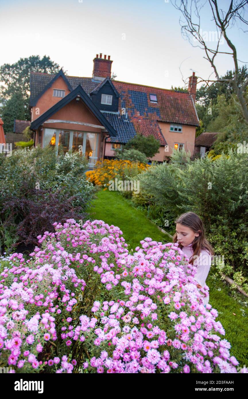 Jeune fille dans un jardin de chalet coloré avec Suffolk, Angleterre, Royaume-Uni Banque D'Images