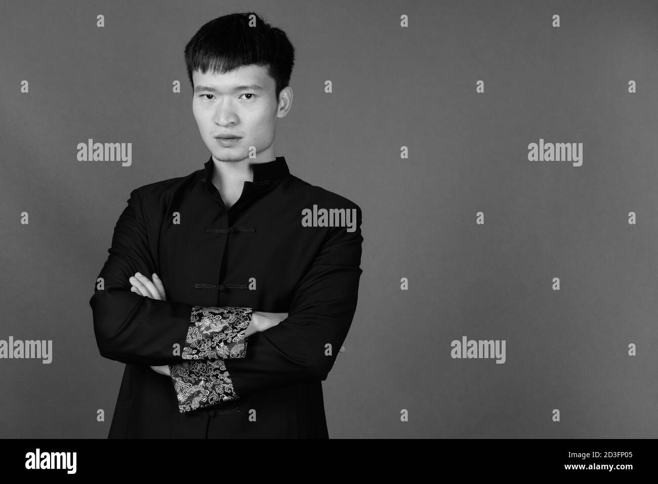 Portrait de jeune homme d'origine chinoise contre l'arrière-plan gris Banque D'Images