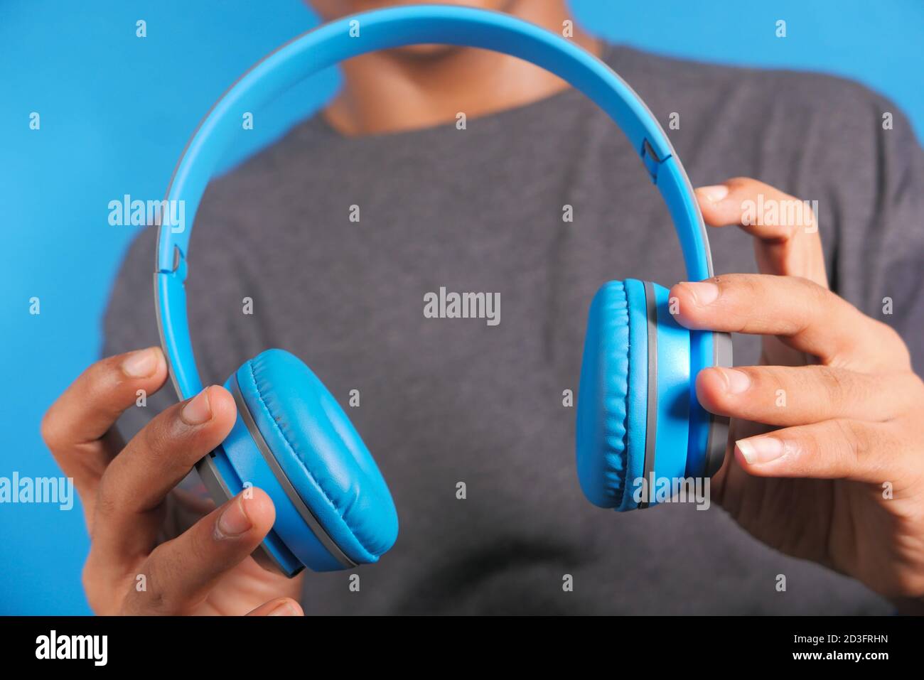 Homme tenant le casque sur fond bleu Banque D'Images