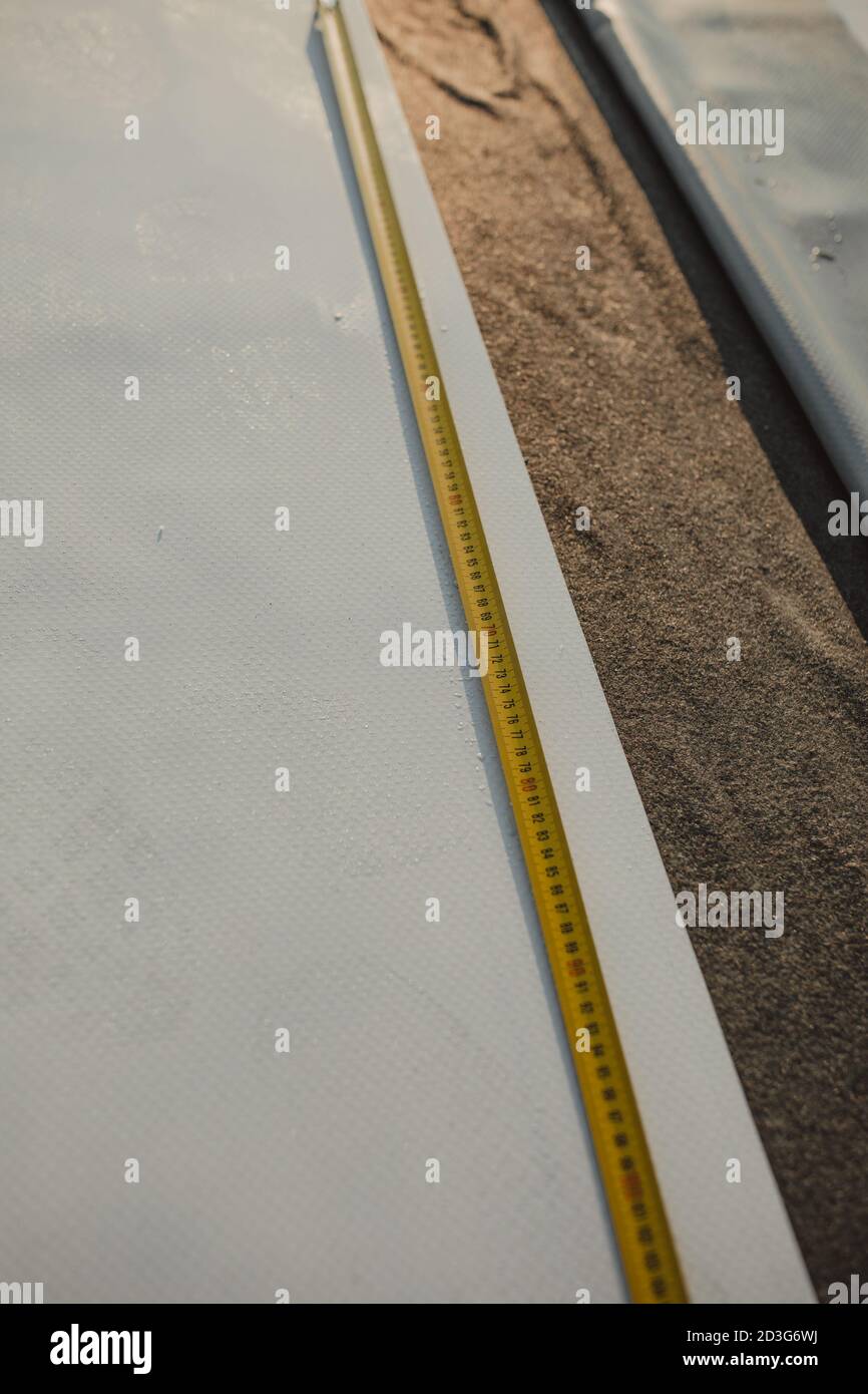 Mètre ruban déployé sur le toit de l'amembrane. Banque D'Images