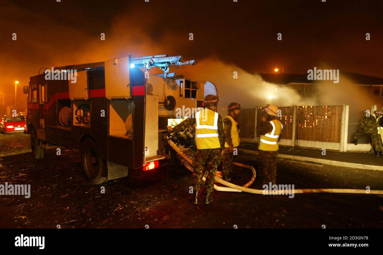 Le personnel de l'armée éteint un incendie de voiture avec des camions de pompiers de la Déesse verte à Manchester, lors d'une grève nationale des pompiers, le 14 novembre 2002. Les pompiers vont faire une grève nationale de 48 heures à compter du 13 novembre, après que leur syndicat a rejeté l'offre de 11 % de salaire. REUTERS/Ian Hodgson IH Banque D'Images