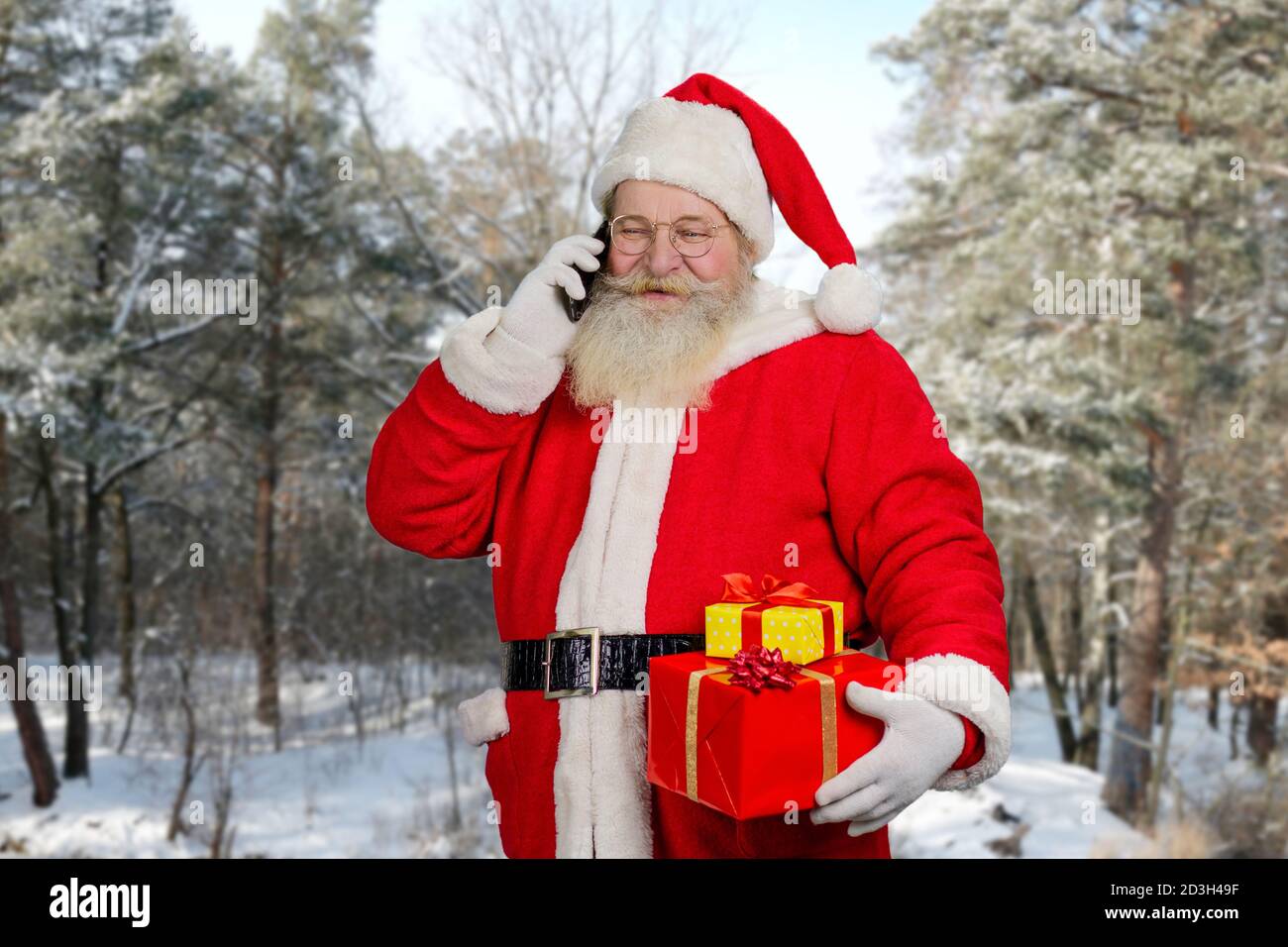 Le Père Noël parle au téléphone à l'extérieur. Banque D'Images