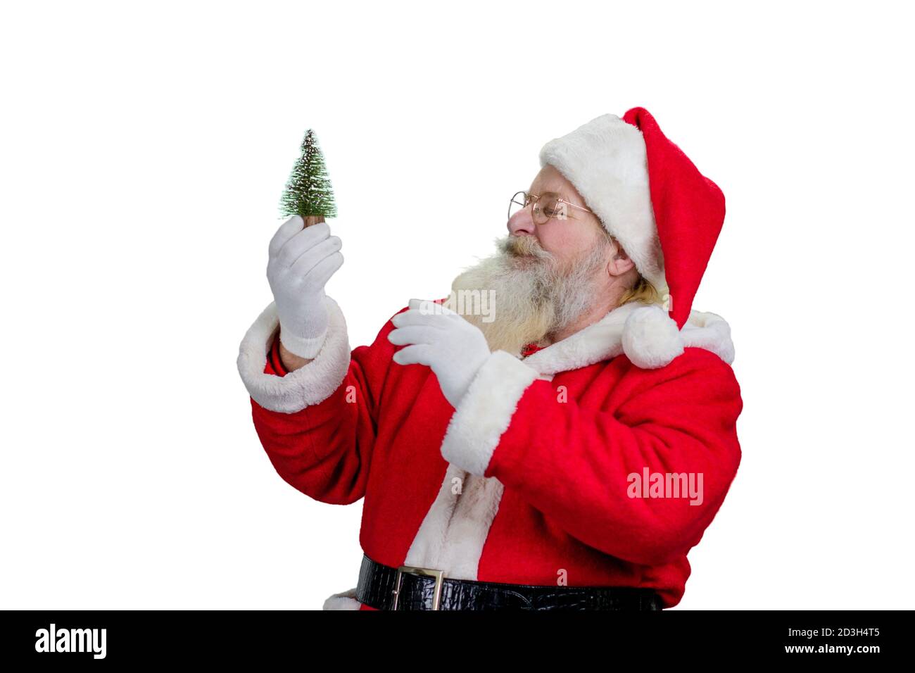 Père Noël tenant un petit arbre de Noël. Banque D'Images