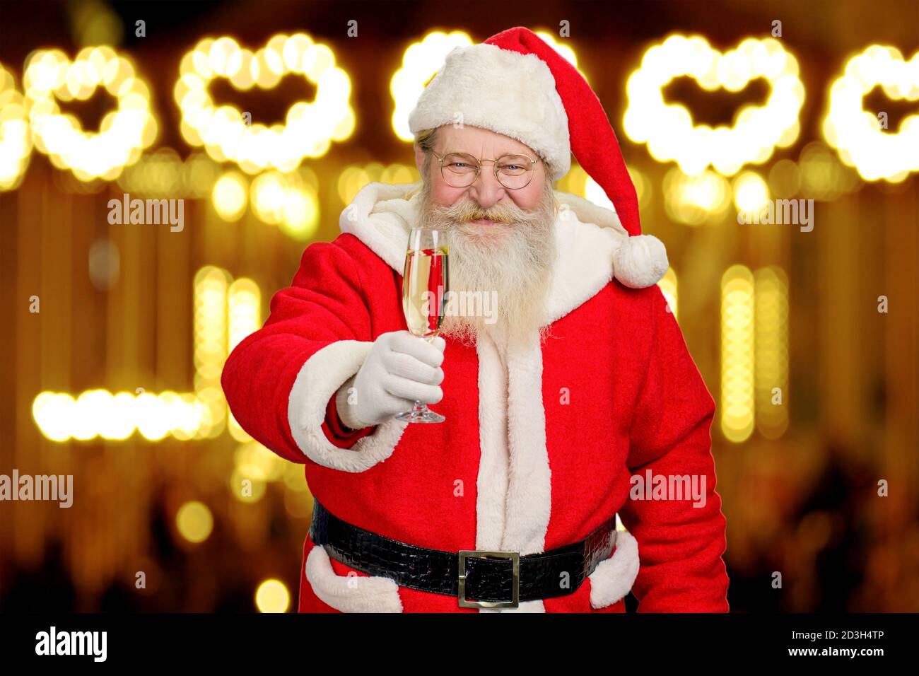 Le Père Noël tient un verre de champagne. Banque D'Images