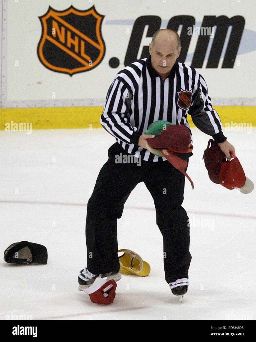 L'homme de ligne de la LNH Ray Scapinello ramasse des chapeaux sur la glace  après le troisième but de l'aile droite de Detroit Red Wings Brett Hull  contre les sénateurs d'Ottawa pendant