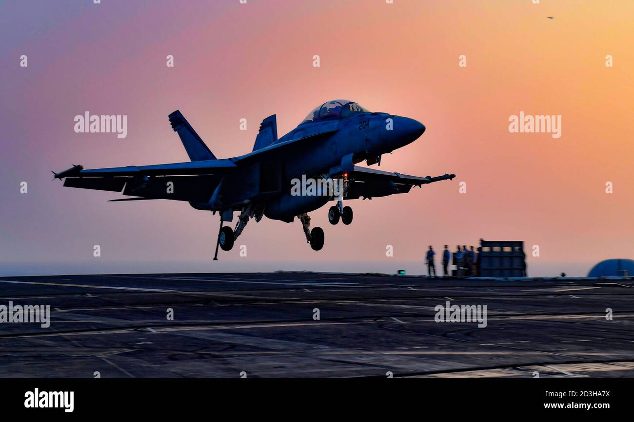 Un avion de chasse F/A-18F Super Hornet de la Marine américaine avec le Mighty Shrikes of Strike Fighter Squadron 94 atterrit au coucher du soleil sur le pont de vol du porte-avions USS Nimitz, Nimitz, le 6 octobre 2020, dans le golfe Arabo-Persique. Banque D'Images