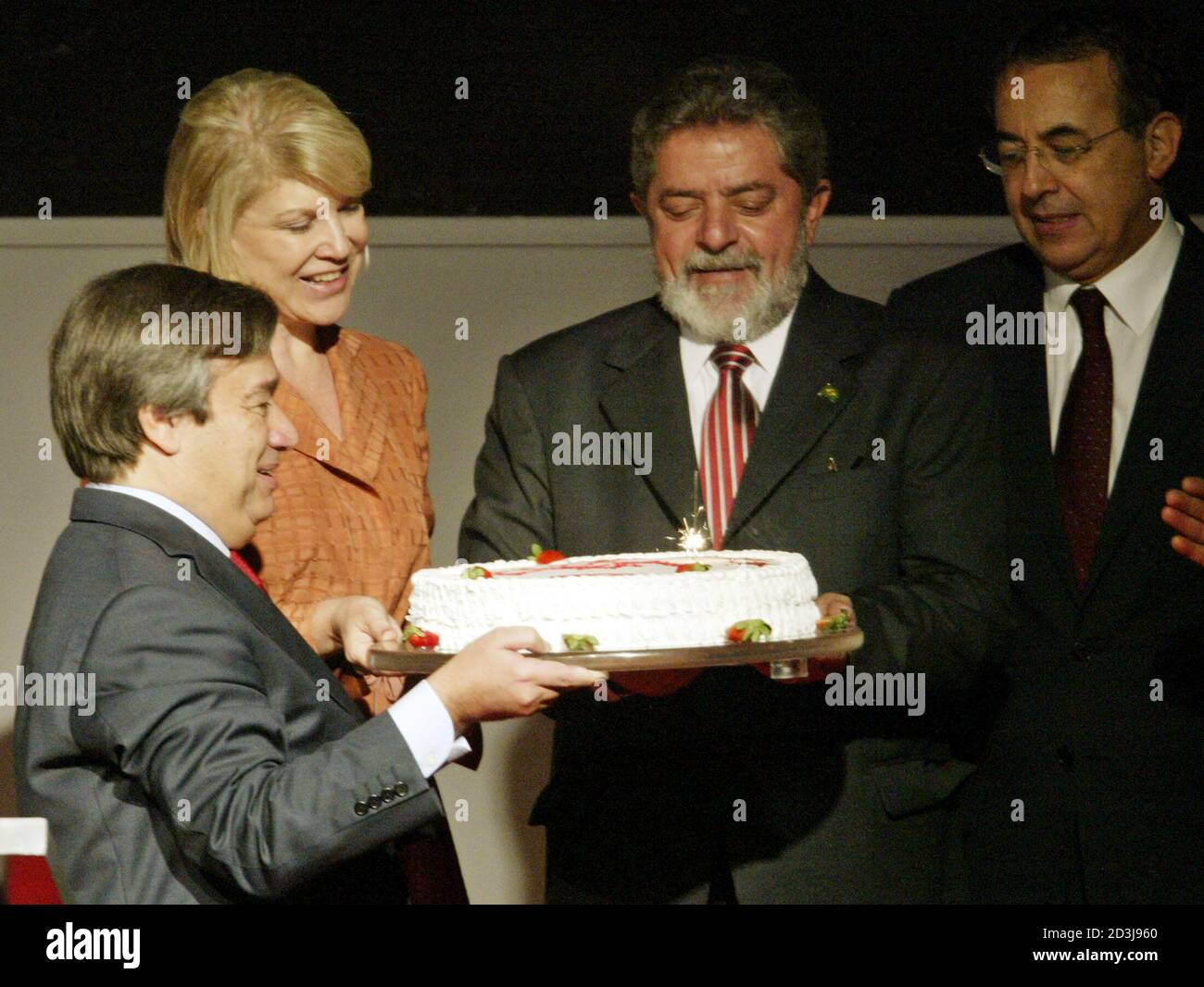 Le Président brésilien Luiz Inacio Lula da Silva (2R) reçoit d'Antonio Guterres (L), ancien Premier ministre portugais et président en exercice de l'Organisation socialiste internationale, un gâteau pour célébrer son 58e anniversaire, lors de la XXII réunion du groupe dans un centre de congrès de Sao Paulo, le 27 octobre 2003. On y regarde le maire de Sao Paulo, Marta Suplicy (2L) et Joao Paulo Cunha, président de la Chambre basse du Congrès brésilien. REUTERS/Paulo Whitaker RR/HB Banque D'Images