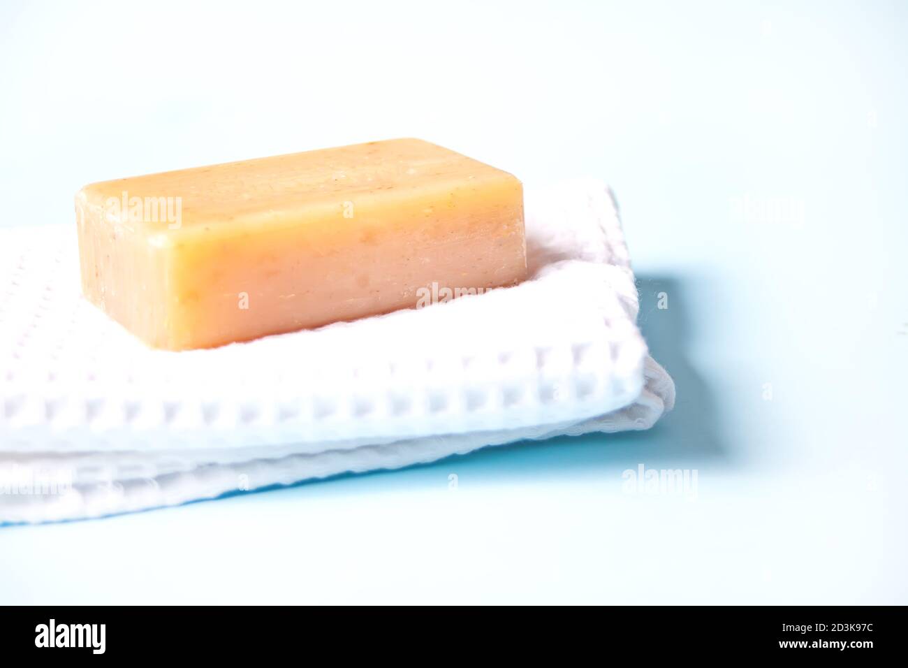 porte-savon sur serviette de bain blanche, fond bleu clair Banque D'Images