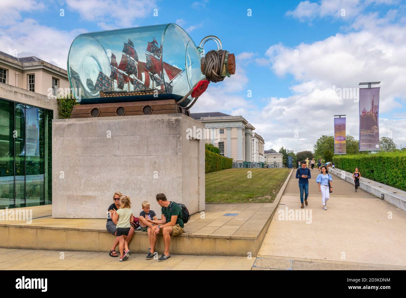 Une famille s'assoit sous le navire de Lord Nelson dans une bouteille, une œuvre d'art de Yinka Shonibare, devant le Musée maritime national de Greenwich, Londres. Banque D'Images