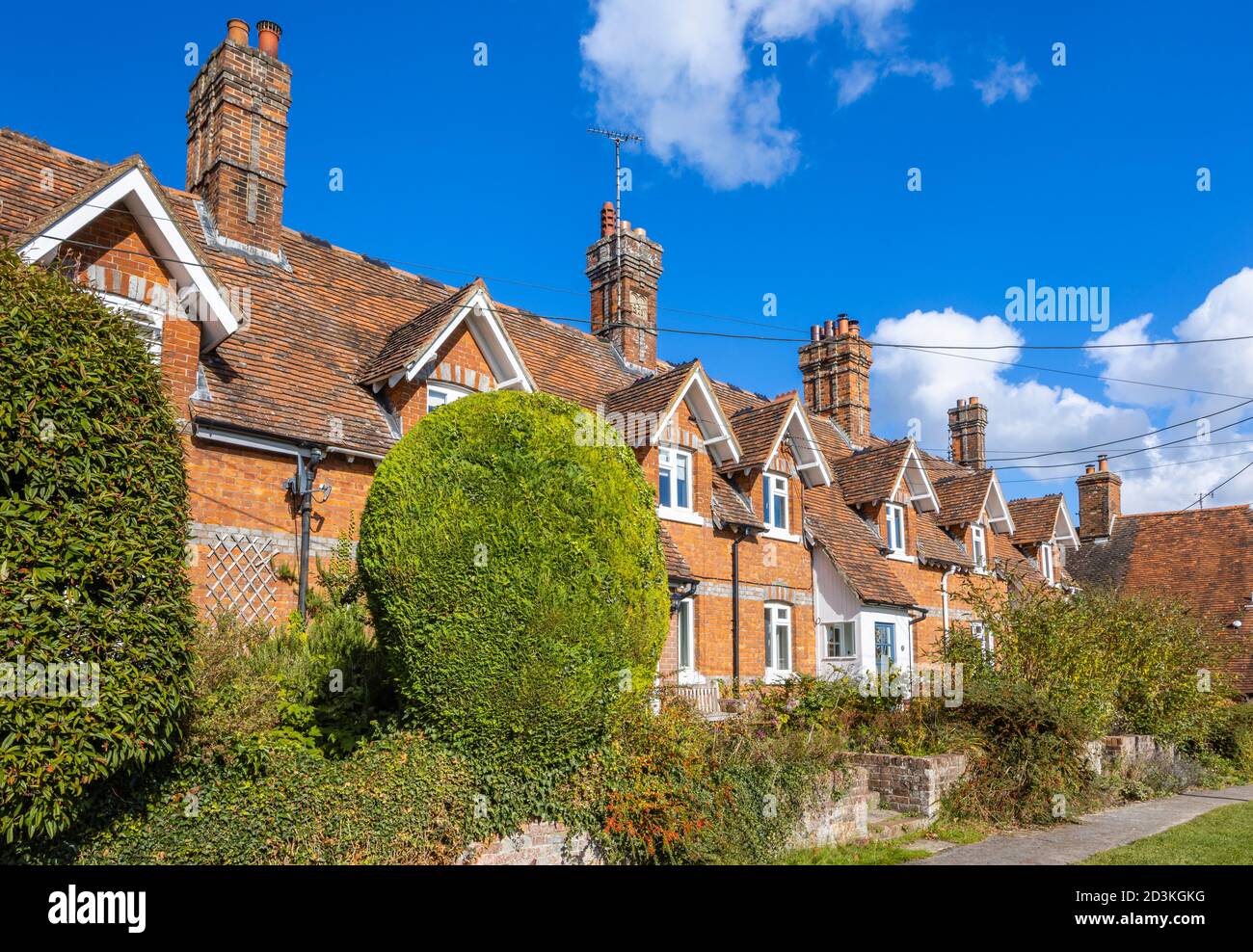 Vue sur les maisons et les chalets en terrasse typiques de briques rouges dans la grande rue principale de Great Bedwyn, un village dans l'est du Wiltshire, dans le sud de l'Angleterre Banque D'Images
