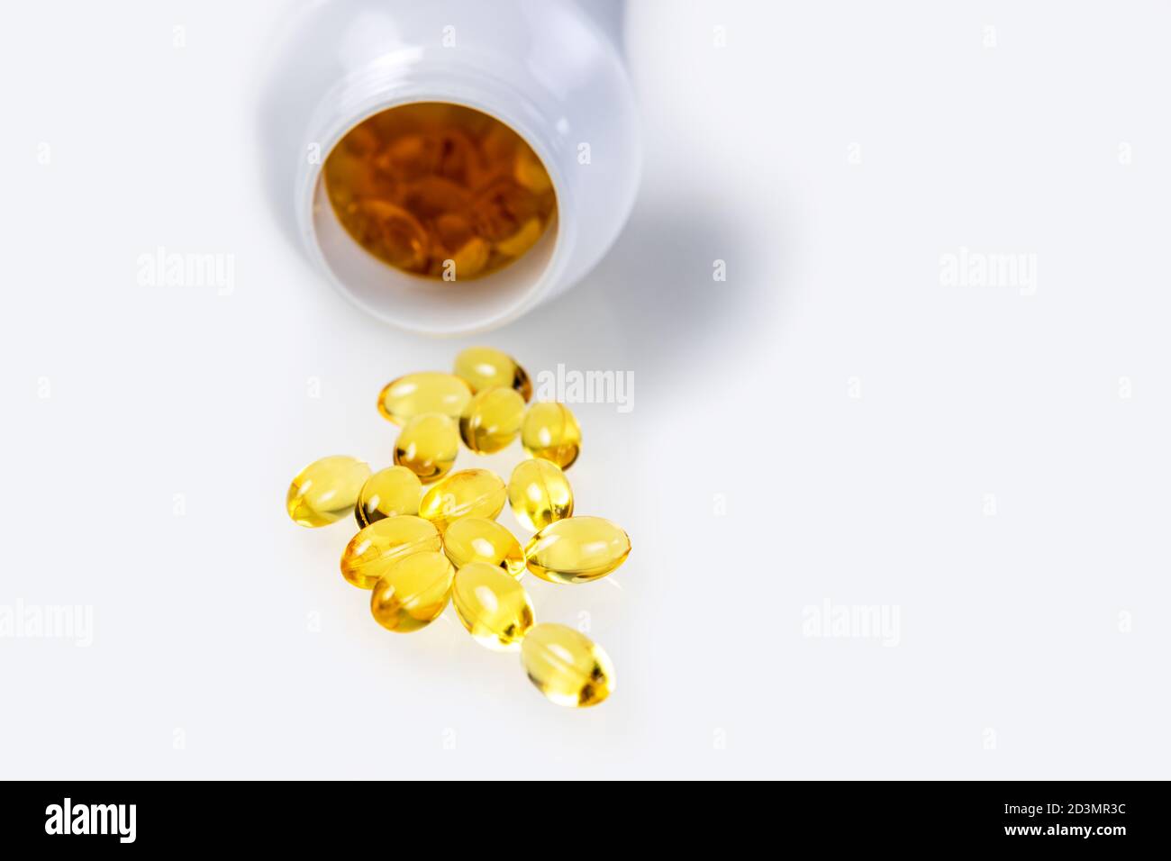 Capsules de vitamine D dispersées sur fond blanc. Additif alimentaire Banque D'Images