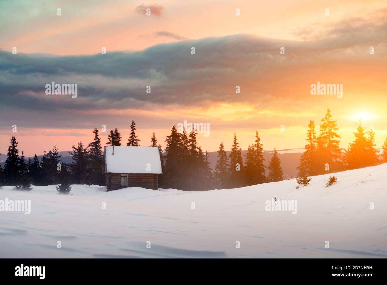 Paysage d'hiver fantastique avec maison en bois dans les montagnes enneigées. Des pics de haute montagne ciel coucher de soleil brumeux. Maison de vacances d'hiver et Noël concept Banque D'Images