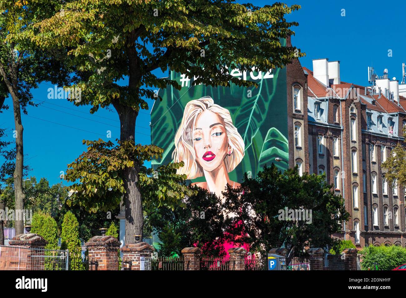 Murale publicitaire avec une femme blonde sur le côté d'un bâtiment à Wola, Varsovie, Pologne Banque D'Images