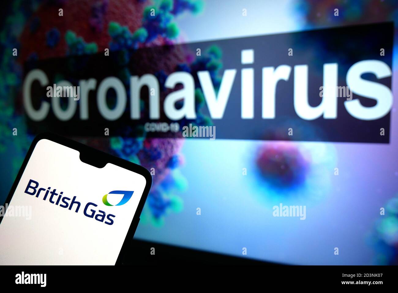 Le logo British Gas affiché sur un téléphone portable avec un modèle d'illustration du coronavirus affiché sur un moniteur en arrière-plan. Banque D'Images