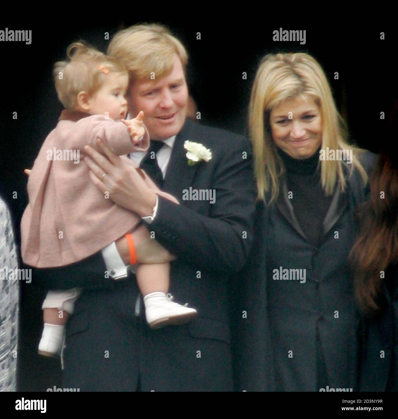 Dutch Crown Prince Willem-Alexander (L) stands next to his wife Princess  Maxima (R) holding his daughter Amalia as she waves at the hearse  containing the coffin of Prince Bernhard as it sets