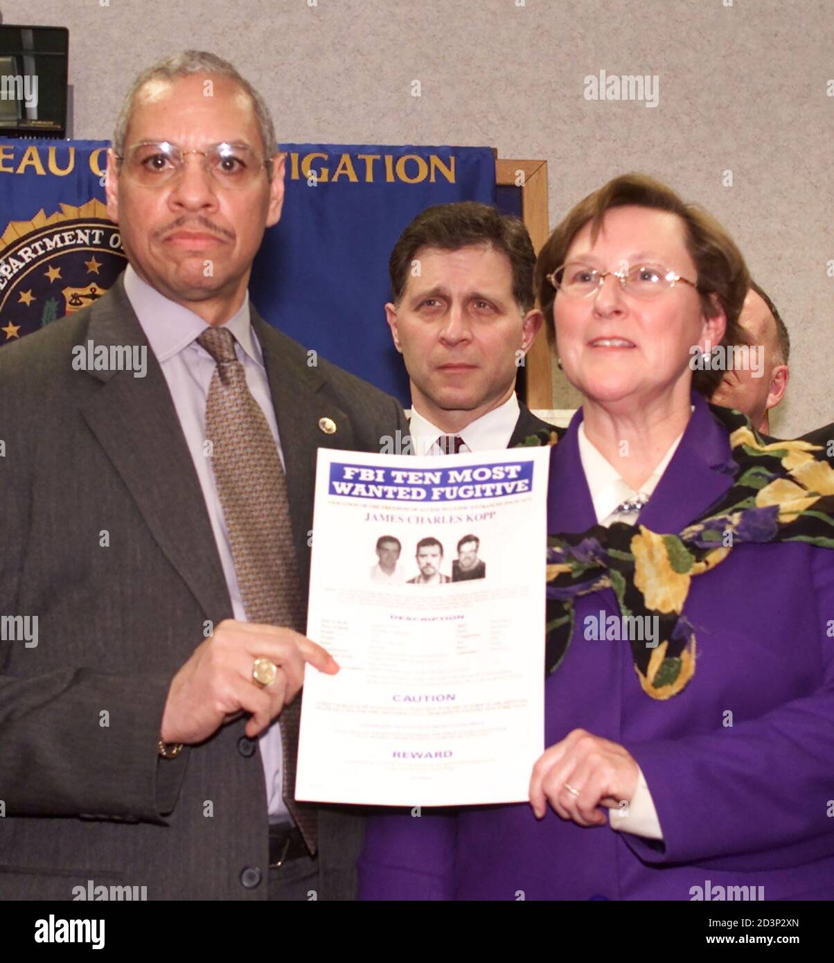 FBI Special Agent in charge Hardrick Crawford Jr. (L), Buffalo Division,  holds up the wanted poster for James Charles Kopp, in Buffalo, March 29,  2001. Kopp, one of the FBI's 10 most