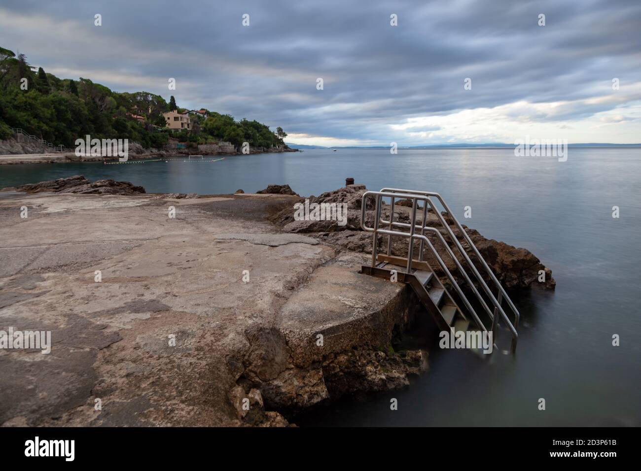 Aube sur une plage de béton avec une échelle en acier inoxydable Banque D'Images