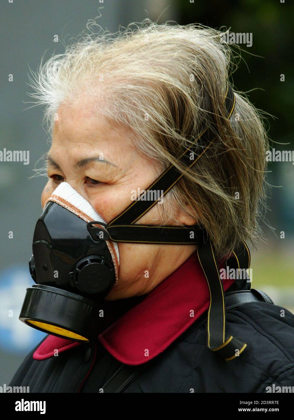 Une femme porte un masque à gaz alors qu'elle se promène à l'extérieur de l' hôpital Prince of Wales de Hong Kong, où les patients diagnostiqués comme  une mystérieuse pneumonie sont soignés le