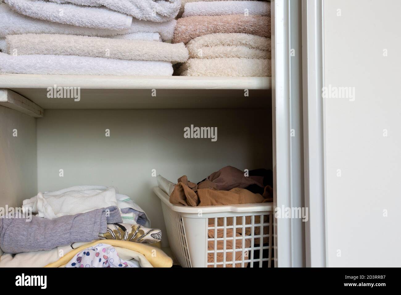 placard complet avec vêtements et pile de serviettes en bois blanc placard, organisation et rangement Banque D'Images