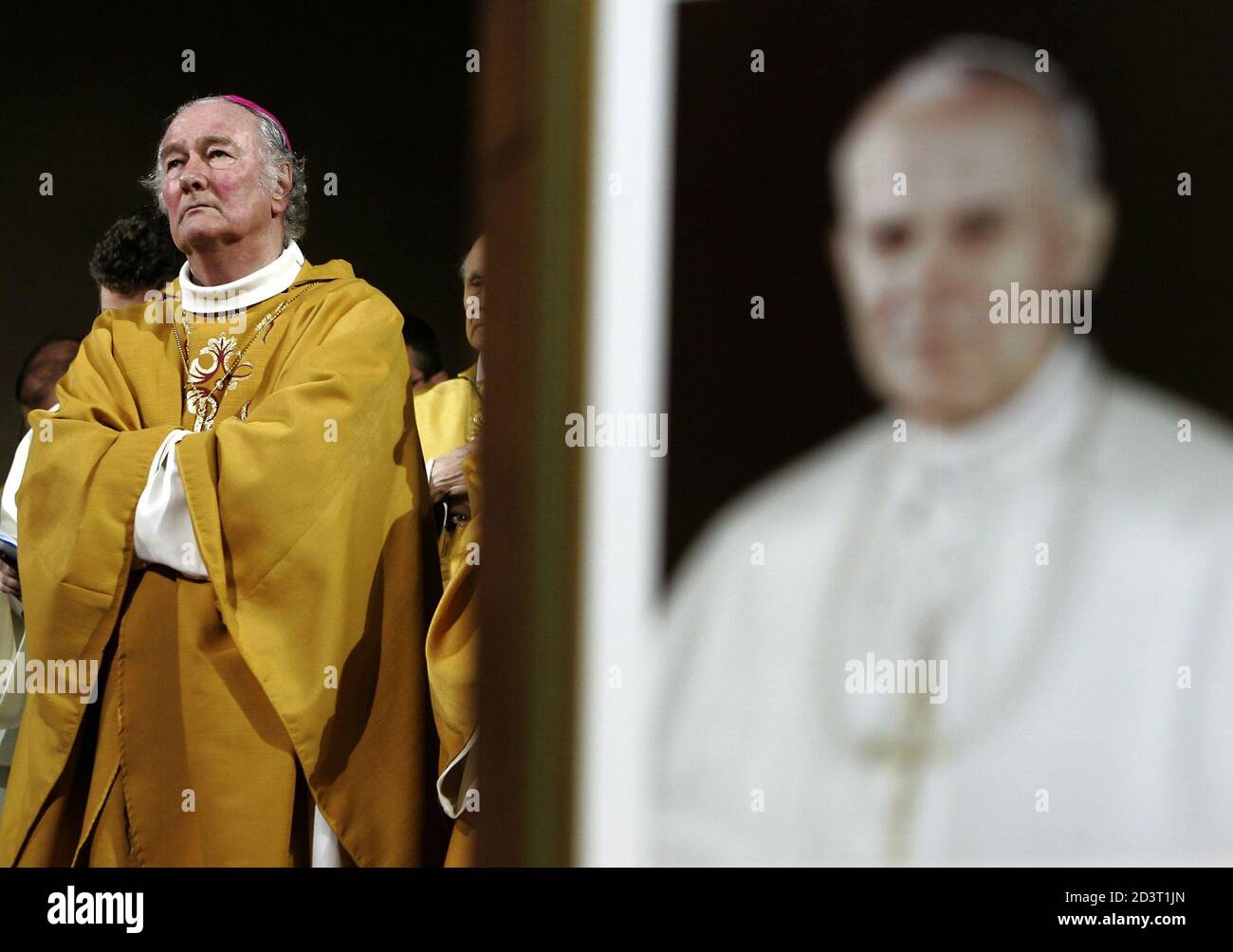 Swiss Bishop Bernard Genoud (L) stands beside a portrait of the late Pope  John Paul II during a special mass in memory of the Pope at the  Dreifaltigkeits Church in Berne, Switzerland,