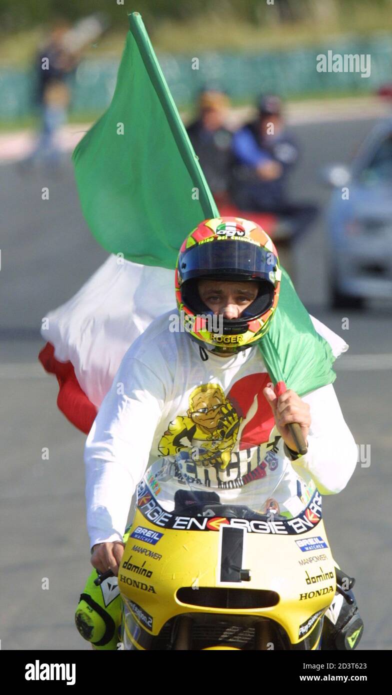 Valentino Rossi, une moto italienne qui porte le numéro un, porte son  drapeau national après avoir remporté le titre mondial de moto 500cc en  remportant le Grand Prix australien de moto 500cc