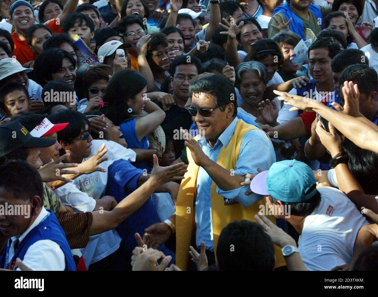 Opposition presidential candidate and actor Fernando Poe Jr is mobbed by  supporters during a campaign stop in Sapang Palay district, in San Jose del  Monte City, 50 km (30 miles) north of