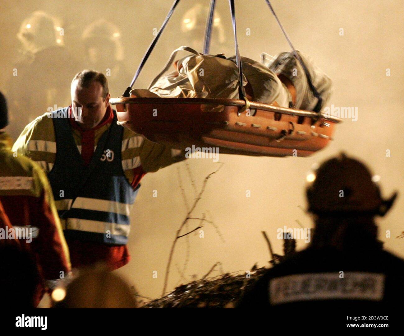 The body of a firefighter is lifted from an underground car park after the roof collapsed and buried up to seven fire fighters in the town of Gretzenbach between the cities of Basel and Zurich November 27, 2004. Construction experts, earthquake rescue specialists and other fire and rescue personnel raced against time to find the men who had been battling a fire in the residential car park when the roof caved in and trapped them in its rubble. Pictures of the month November 2004 REUTERS/Ruben Sprich RS/WS Banque D'Images