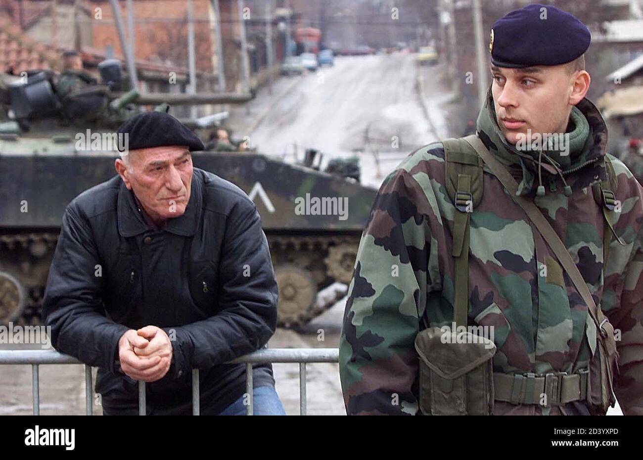 An Ethnic Albanian Man Looks At A French Kfor Soldier On Guard On The Street Of The Ethnically Mixed Little Bosnia District In The Kosovo Flashpoint Town Of Kosovska Mitrovica January 30 2001
