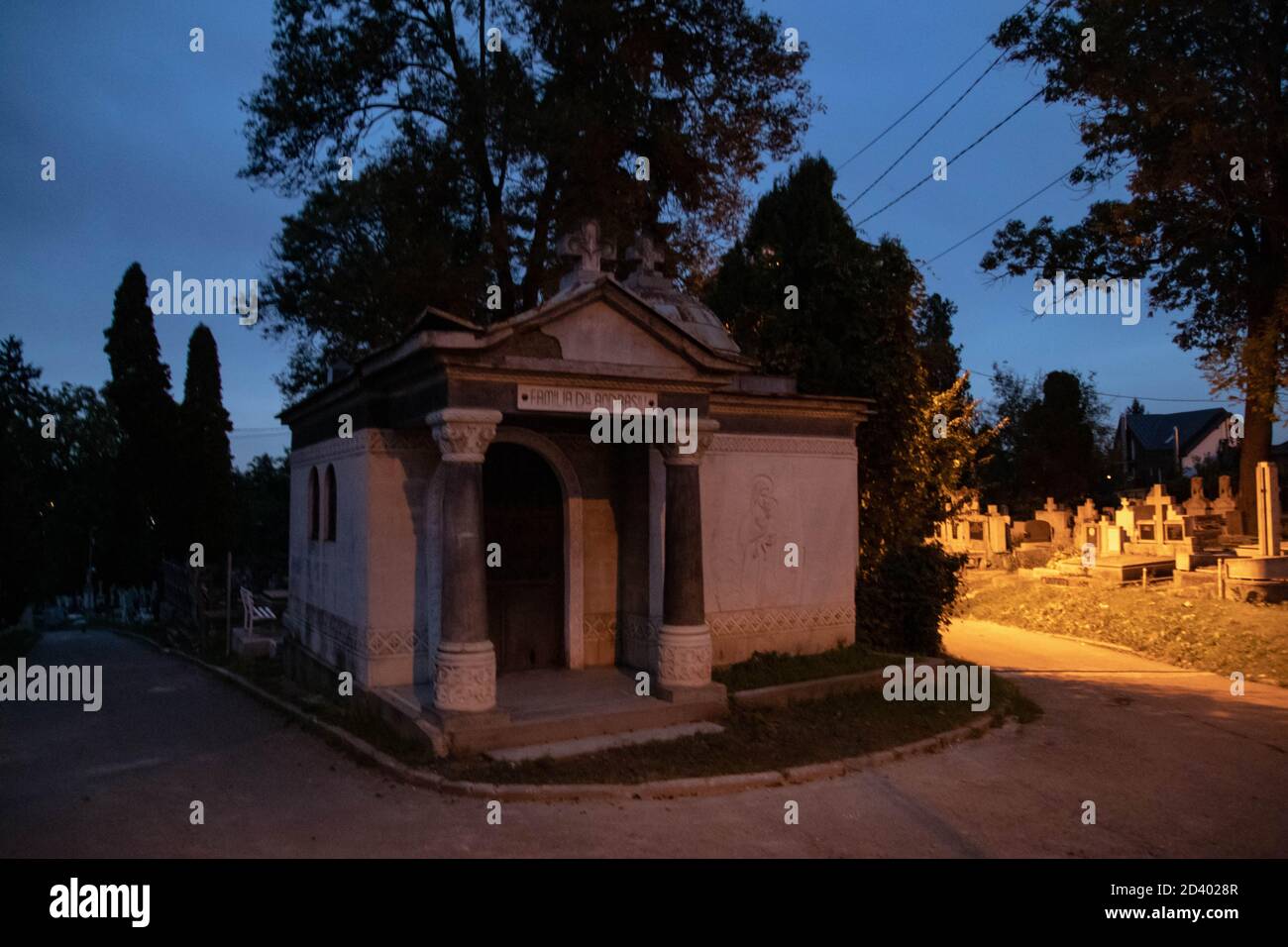 Une tombe au milieu du cimetière le soir et aussi au milieu de l'allée. Dans une architecture d'Europe de l'est Banque D'Images