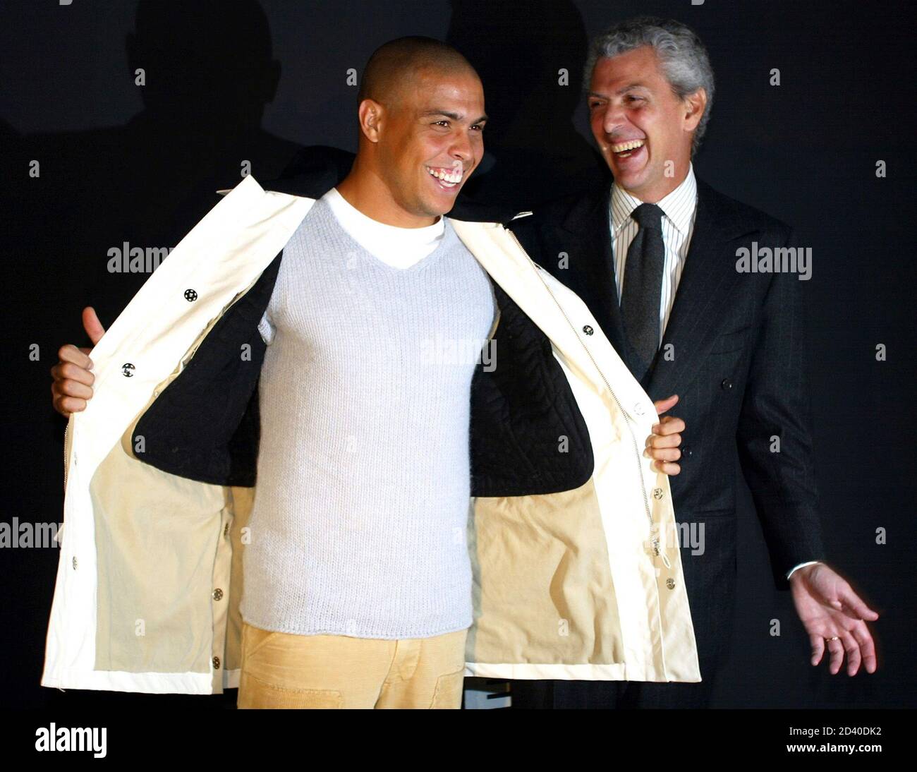 Ronaldo (L), star du football brésilien Inter Milan, sourit en présentant  une veste avec le président de Pirelli, Marco Tronchetti Provera, lors  d'une présentation de leur collection de vêtements de sport 2002