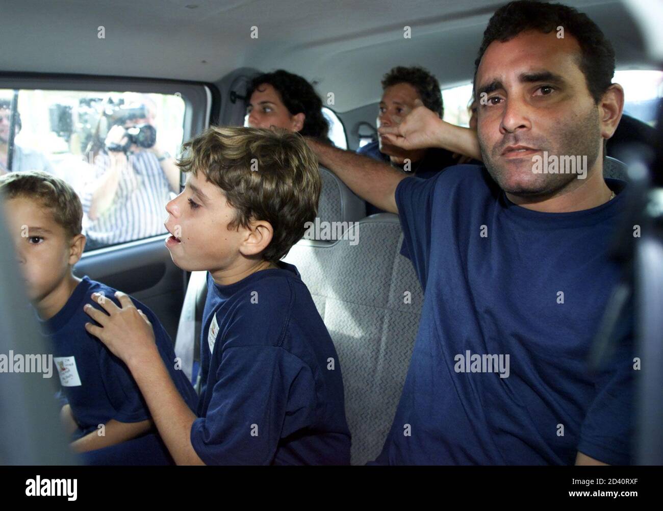 Pauel Puig (R) sits in a van with Donny Iglesias Martinez (L) and Eddie  Iglesias Martinez (C) as the parents of the two boys, Mercedes  Martinez-Paredes and Lenin Iglesias Hernandez sit in