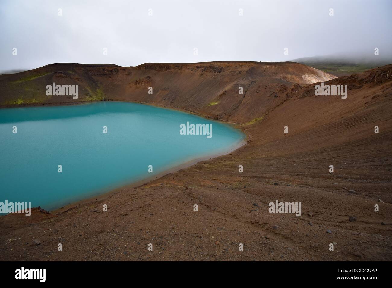 Le lac bleu vert à l'intérieur du cratère Krafla Viti dans la région du lac Myvatn dans le nord de l'Islande sur fond de nuages blancs. Banque D'Images
