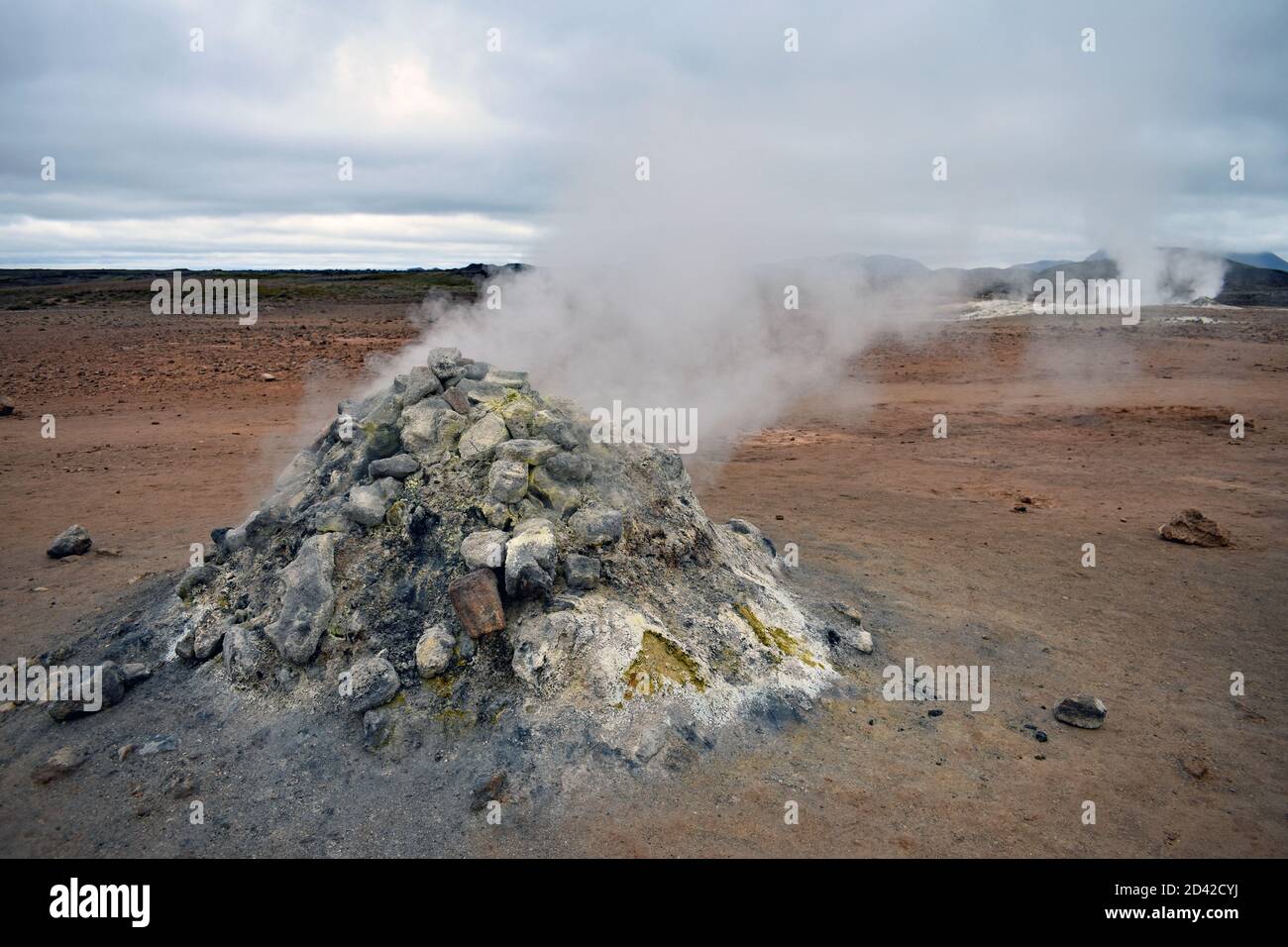 Le Smoker Sulfurique dans la zone géothermique de Hverir près du lac Myvatn, dans le nord de l'Islande. De la vapeur s'échappe des évents à vapeur dans un paysage de couleur orange. Banque D'Images