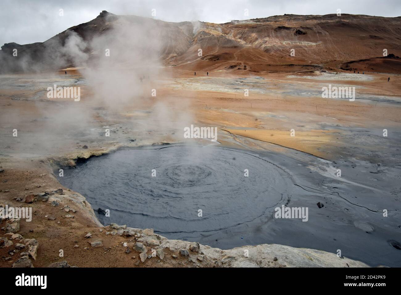 Námafjall Hverir point de vue près du lac Myvatn dans le nord de l'Islande. Les piscines de boue bouillante émettent de la vapeur sulfurique sur un fond de montagne orange et brun. Banque D'Images