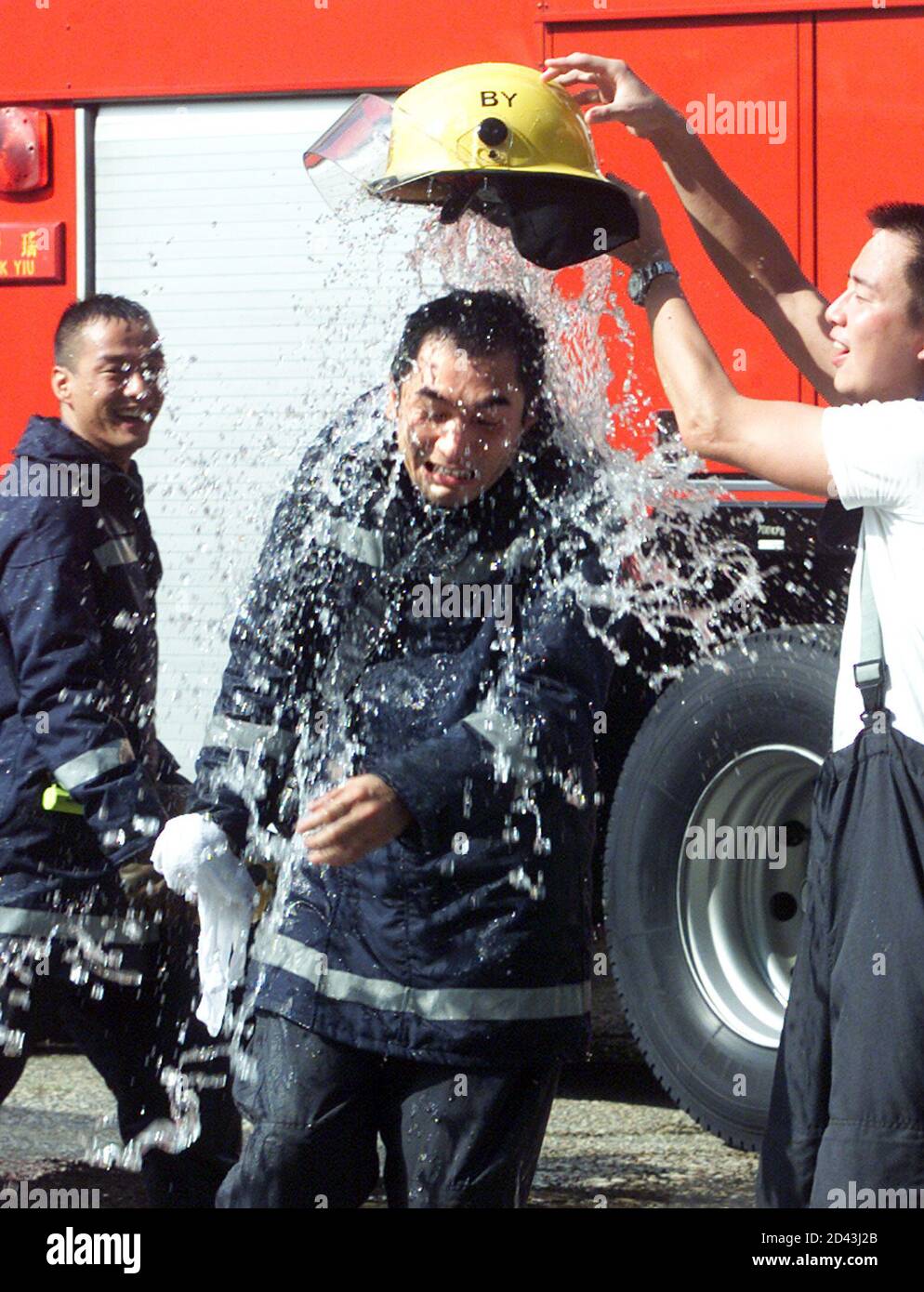 L'acteur de Hong Kong Alex Fong (C), vêtu d'un pompier, se rafraîchit lors d'une pause dans le 