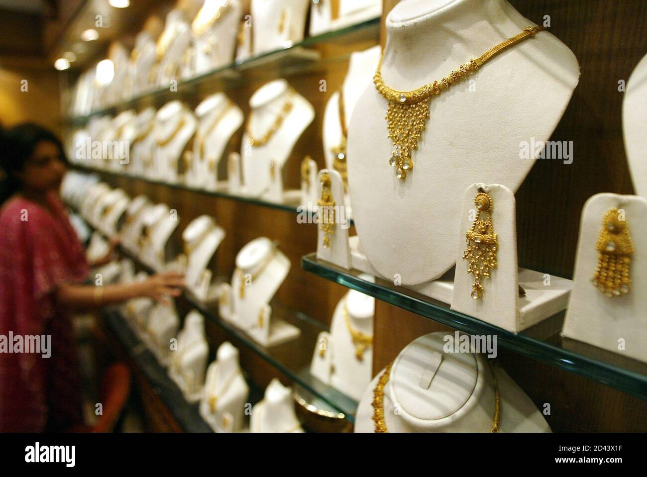 A saleswoman arranges gold jewellery at a shop in Bombay November 9, 2004.  Jewellery consumers, undeterred by gold's rise to a 16-year high, are  making last-minute purchases this week before religious festivals