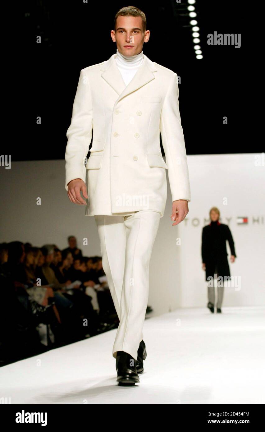 Un modèle pour le designer Tommy Hilfiger marche sur la piste en portant un  blazer militaire en laine blanche d'hiver, un pull à col roulé en laine  blanche d'hiver et un pantalon