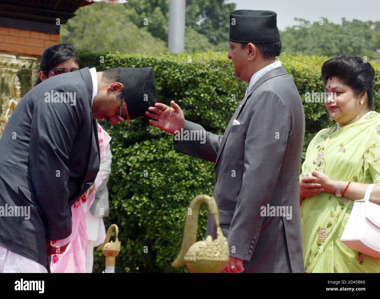 Le roi Gyanendra du Népal bénit son fils le prince héritier Parash à l'aéroport international Tribhuvan de Katmandou. Le roi Gyanendra du Népal (R) bénit son fils le prince héritier Parash (L) à l'aéroport international de Tribhuvan à Katmandou le 13 juin 2005 avant de partir pour Doha pour participer au deuxième sommet des pays en développement. On s'attend à ce que le roi cherche un soutien international pour son gouvernement, qu'il a pris en charge en prenant la relève d'un premier ministre démocratiquement élu en février. REUTERS/Gopal Chitrakar Banque D'Images