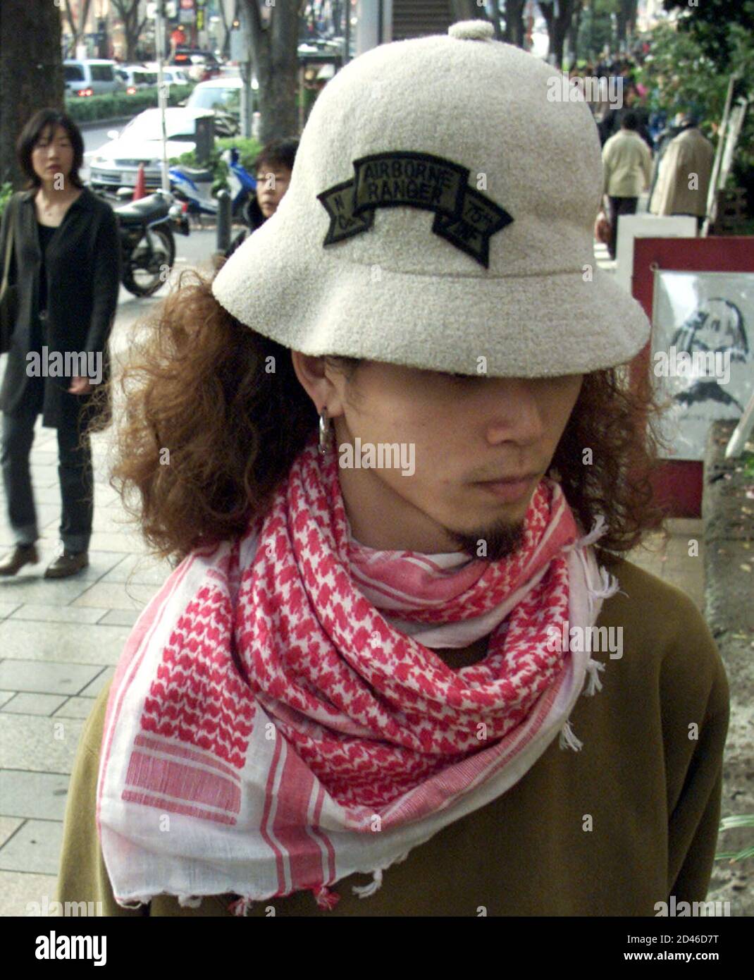 Un Japonais porte un foulard en coton du Moyen-Orient à Tokyo le 28 octobre  2001. Cyber-baskets, pantalons camouflage, un choc de cheveux roses - et  comme une touche finale, un « foulard
